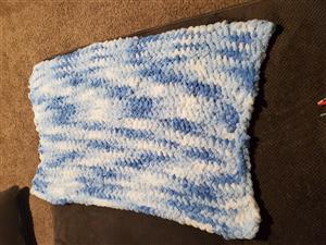 A blue and white baby blanket Ms. Mozell finger knit 